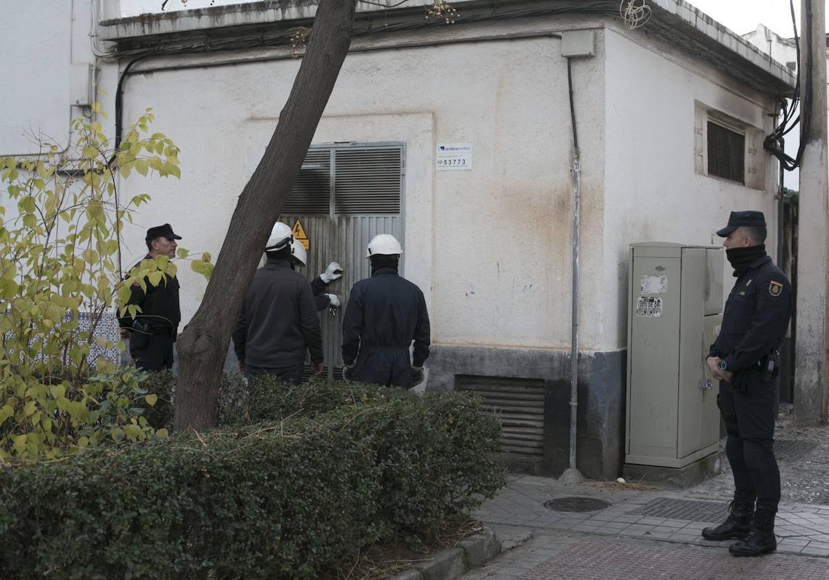 Operadores de Endesa reparan un transformador incendiado en el distrito Norte de Granada escoltados por la Policía Nacional.