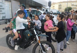 Menores subidos en una motocicleta de la Guardia Civil