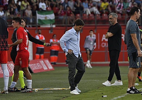 Rubi, mirando al césped, lamenta la expulsión de Arribas, que abandona el campo detrás.