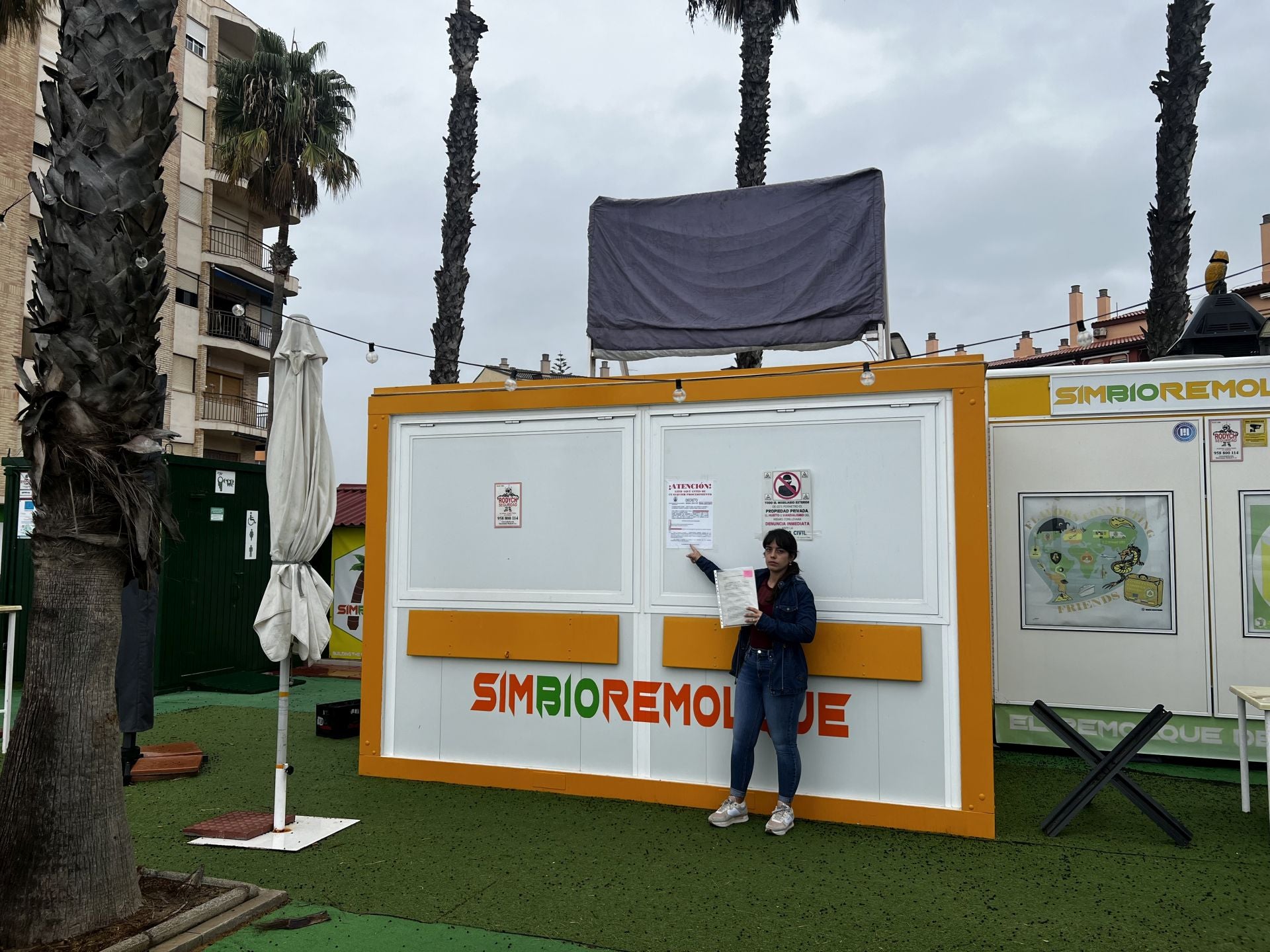 Maria posa junto a su restaurante señalando la licencia de ocupación hasta final de año.