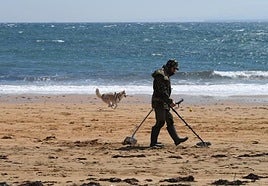Imagen de archivo de un hombre haciendo uso de un detector de metales en una playa.