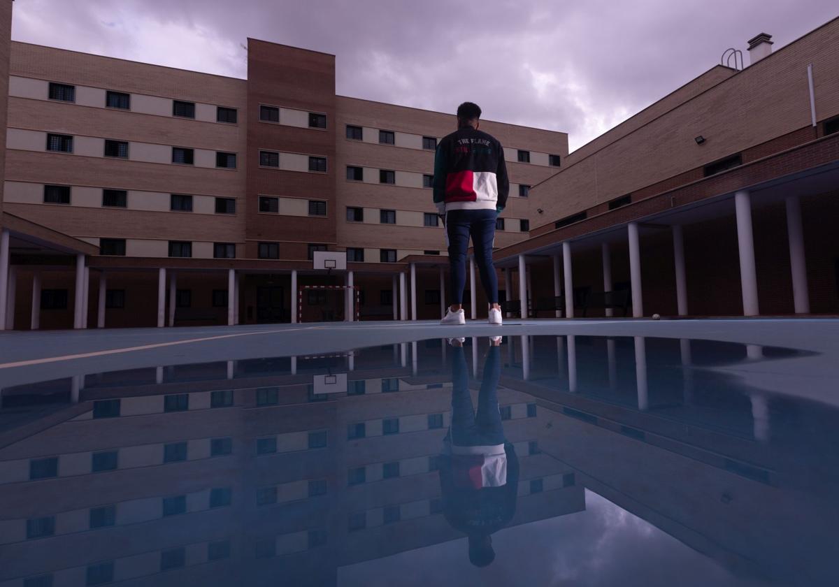 Un interno del centro de inserción social mira el edificio donde están las celdas desde el patio del recinto.