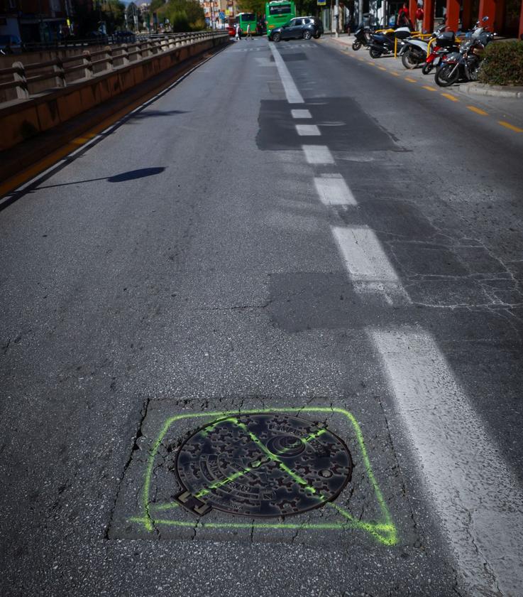 Uno de los agujeros en torno a una alcantarilla que se han señalizado para arreglarlo.