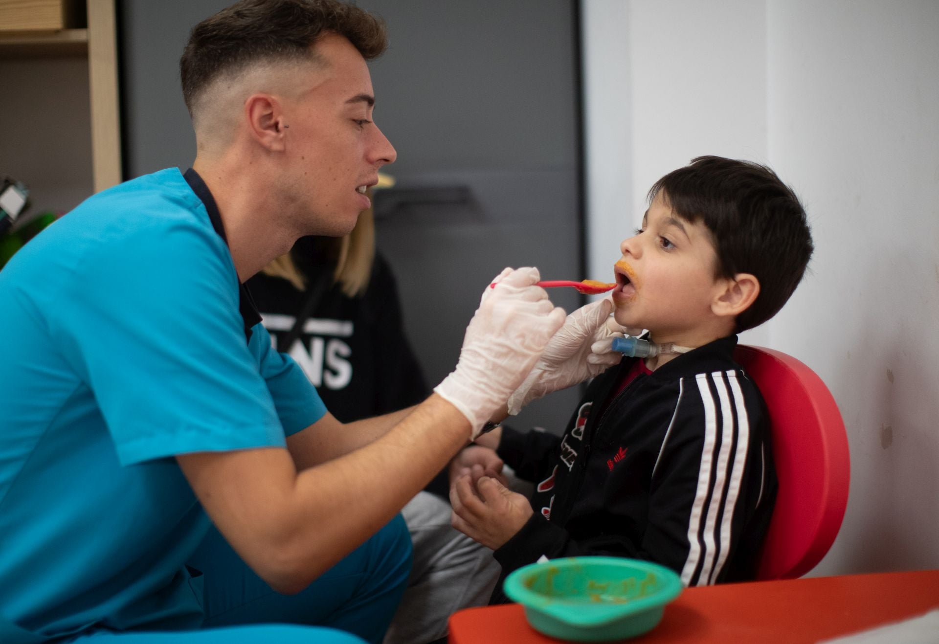 Rafael Gómez, terapeuta ocupacional, enseña a Miguel a comer.