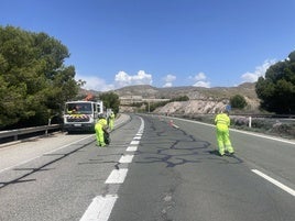 Operarios de conservación de carreteras, en un tramo de vía.