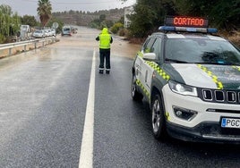 Un agente de Guardia Civil en una vía inundada.