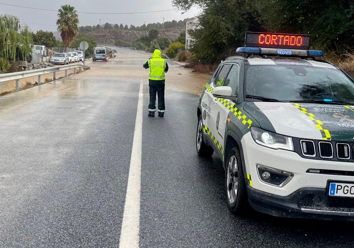 Un agente de Guardia Civil en una vía inundada.