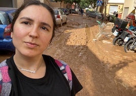 Elena muestra el lodo de una de las calles de Valencia.