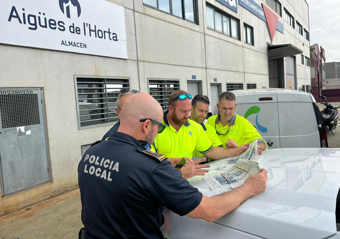 Policías y técnico estudian el plano de suministro de agua.