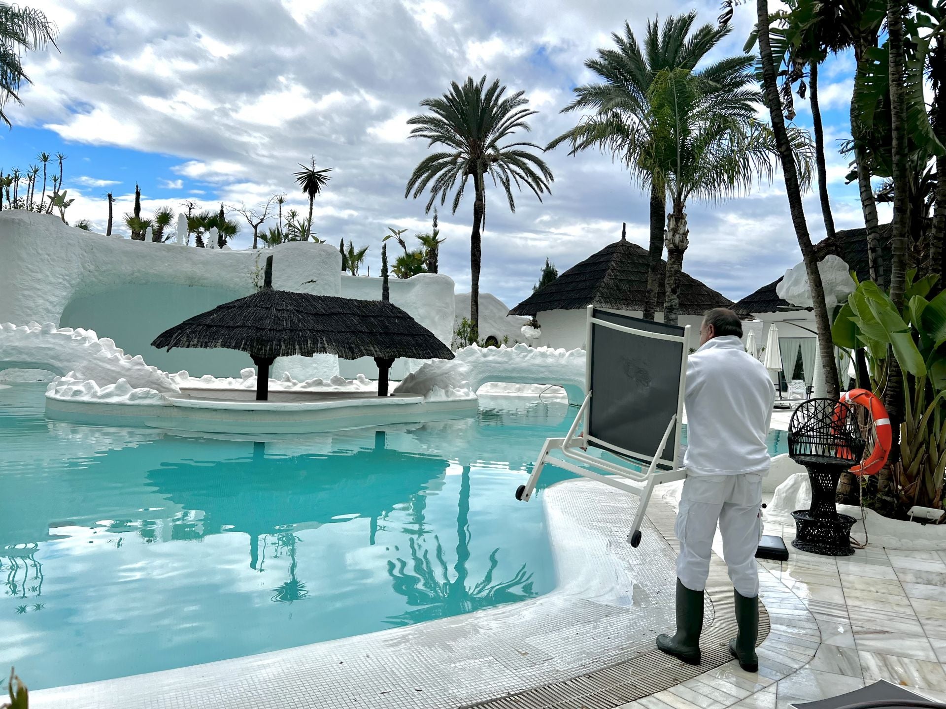 Operario de mantenimiento recogiendo las hamacas de la piscina del Hotel Albayzín del Mar para su cierre.