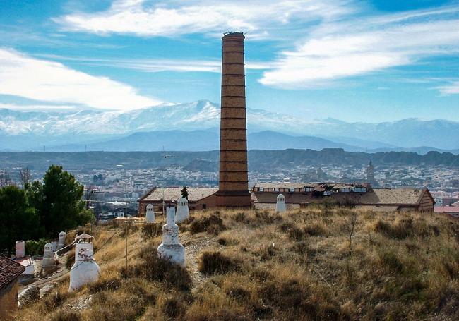 Chimenea de la azucarera de Guadix con Sierra Nevada como telón de fondo.