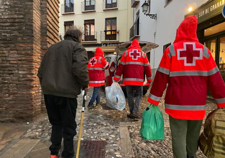 Voluntarios ayudan al trasladarse a una persona sin hogar.