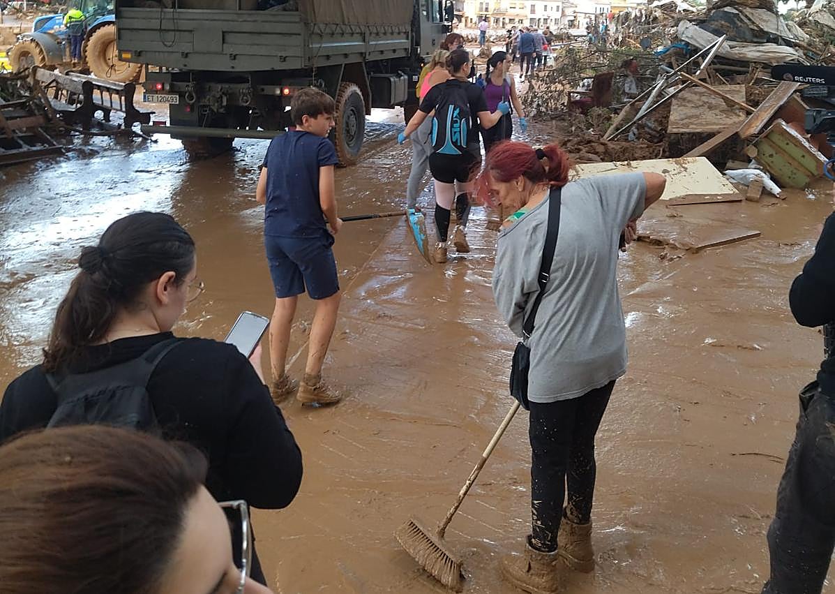 Imagen secundaria 1 - El puente de Picaña sobre el barranco del Poyo, destrozado. Vecinos limpiando el barro. José, en la puerta de su casa, con la marca que dejó la riada.