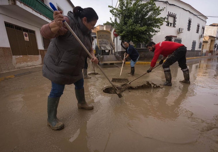 Vecinos afectados ayudan a desaguar las calles en Chauchina.