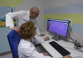 Clara Chamorro y Javier López observan una imagen de microscopio de células cancerígenas en un intestino.