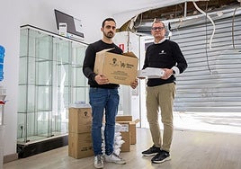 Francisco Jesús y Daniel posan en el local de su tienda de móviles, con la puerta destrozada detrás.
