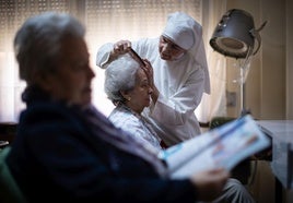 Sor Adelina, de 87 años, atendiendo en la peluquería a las residentes.