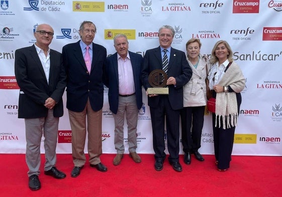 Rafael Morales, con acompañantes de la Peña El Taranto, enseña el premio recibido.