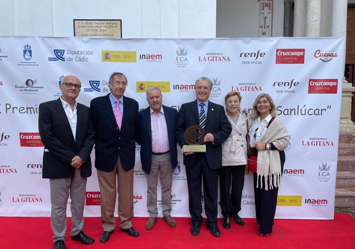 Rafael Morales, con acompañantes de la Peña El Taranto, enseña el premio recibido.