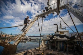 Jesús decapando la pintura de su barco.