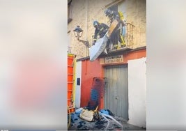 Los bomberos lanzando el colchón a la calle