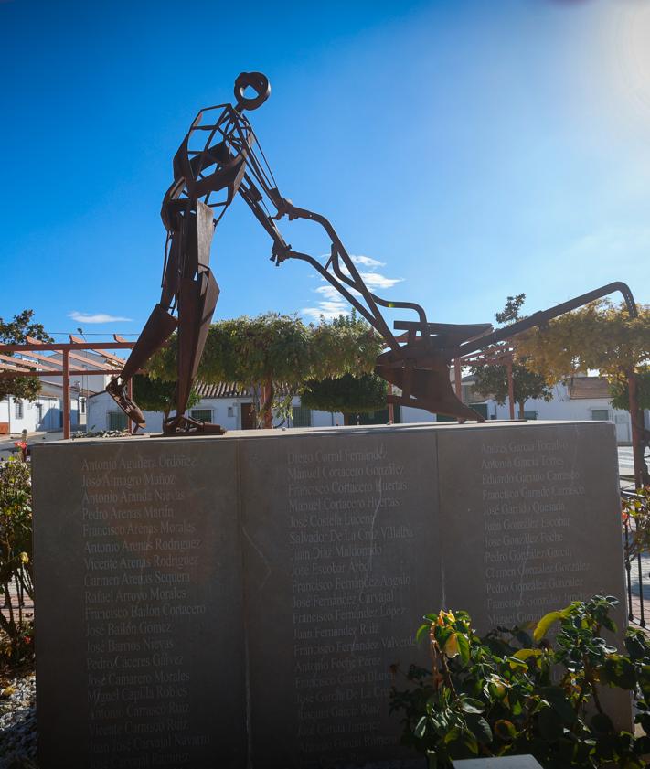 Imagen secundaria 2 - Arriba, Claudio Hernández Burgos, ante la iglesia del pueblo. A la izquierda, el pueblo en los años sesenta, A la derecha, monumento municipal a los colonos. 