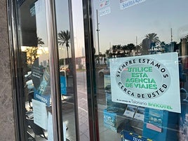 Cartel en la puerta de entrada de la agencia de viajes, cerrada.