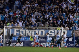 Los jugadores de la UD Almería celebran el gol del empate que lamentan los malaguistas.