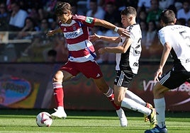 Gonzalo Villar avanza ante el acoso de los futbolistas del Burgos en El Plantío.