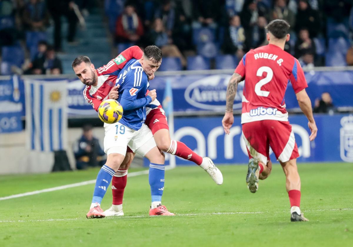 Insua cuerpea por un balón con Viñas en Oviedo.