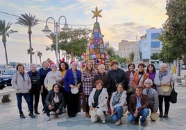 Las mujeres de la asociación posan con el árbol de Navidad.