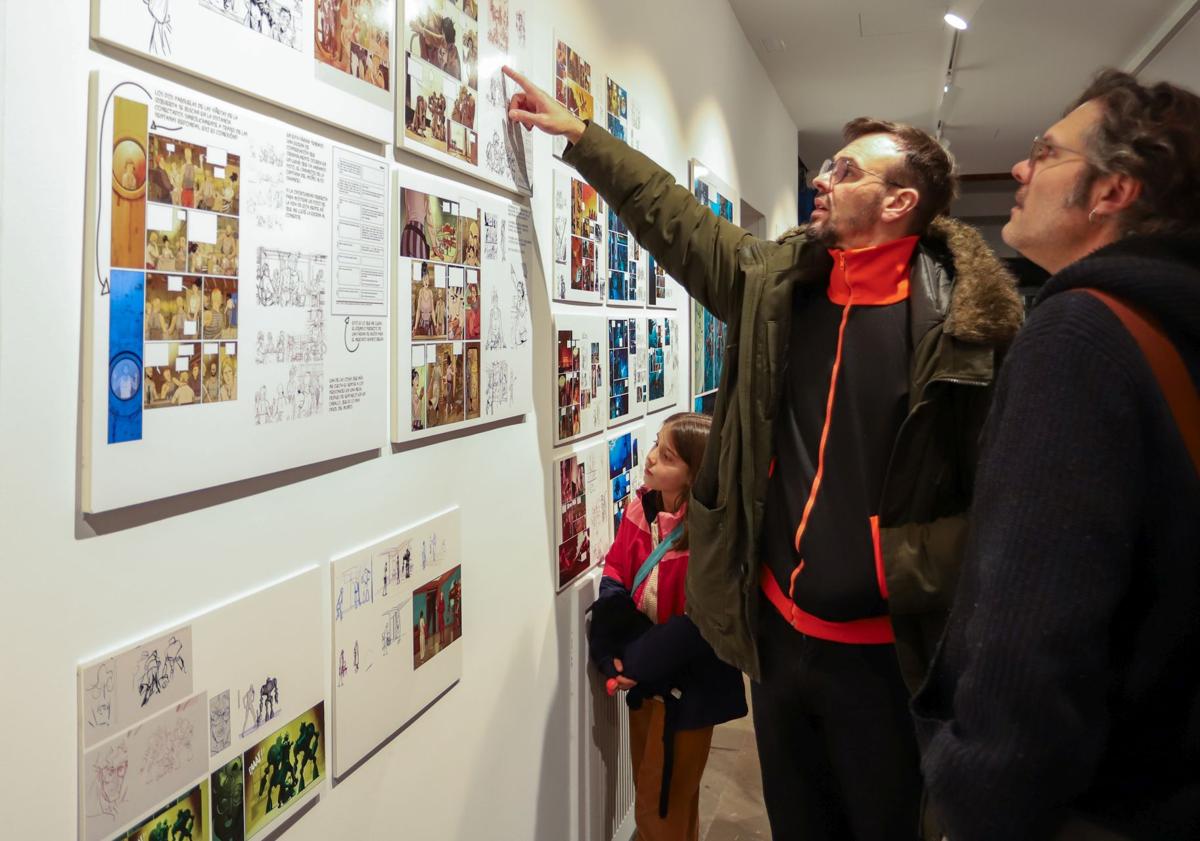 Imagen principal - Kenny Ruiz observa una de las viñetas; Francis, con una maqueta de la ciudad; y la escafandra impresa en 3d. 