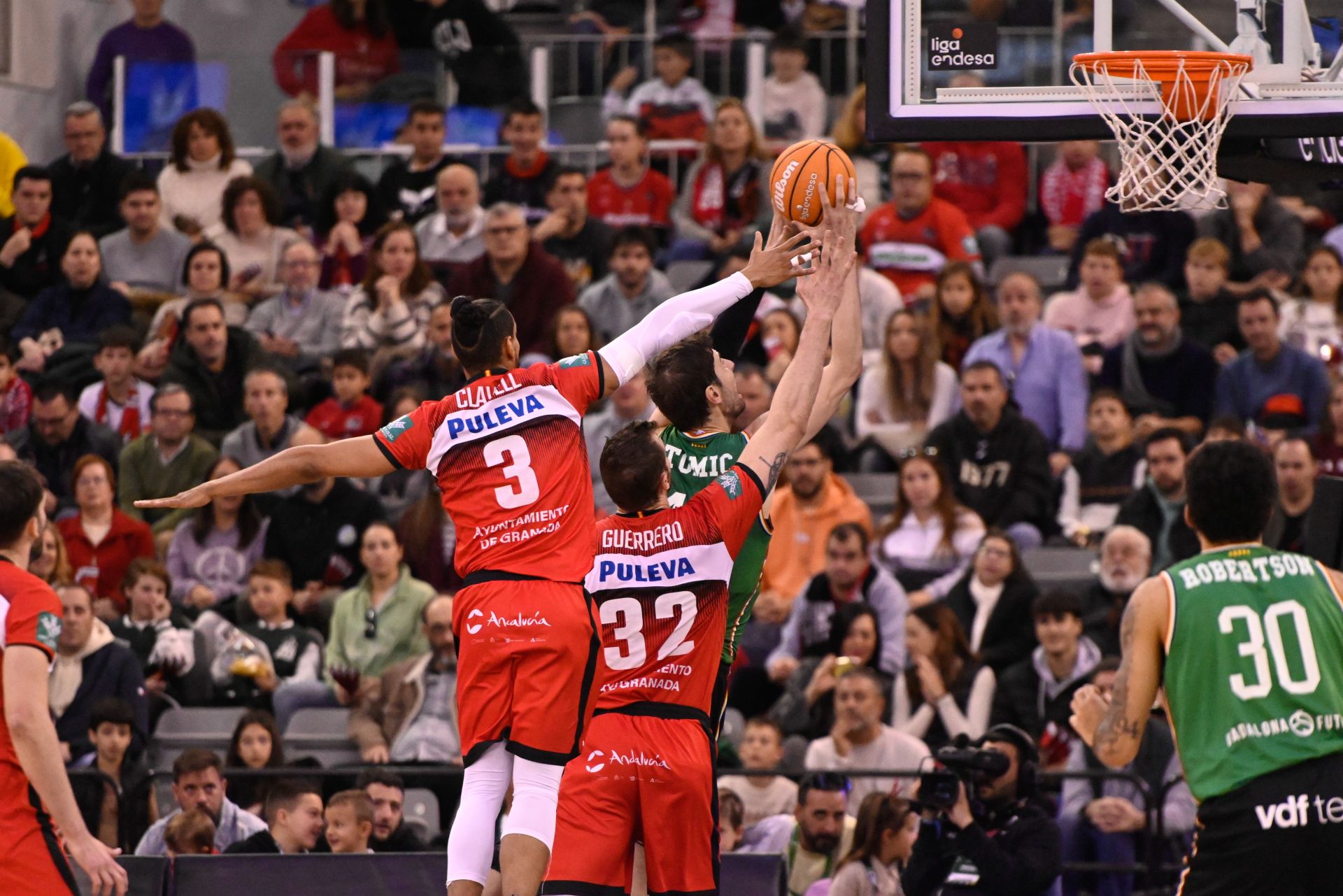 Ayuda defensiva de Gian Clavell a Rubén Guerrero en una tiro de Tomic en el poste bajo.