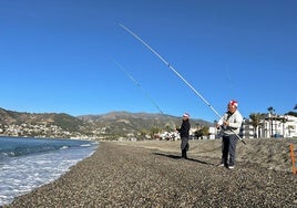 Manuel y Juan pescan con sus gorros de Navidad.