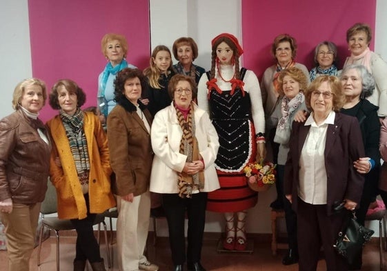 Mujeres de Campillo de Arenas posan junto a la figura de aldeana que han confeccionado este año.