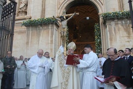 El obispo sostiene el Cristo de la misericordia momentos antes de atravesar la puerta del perdón