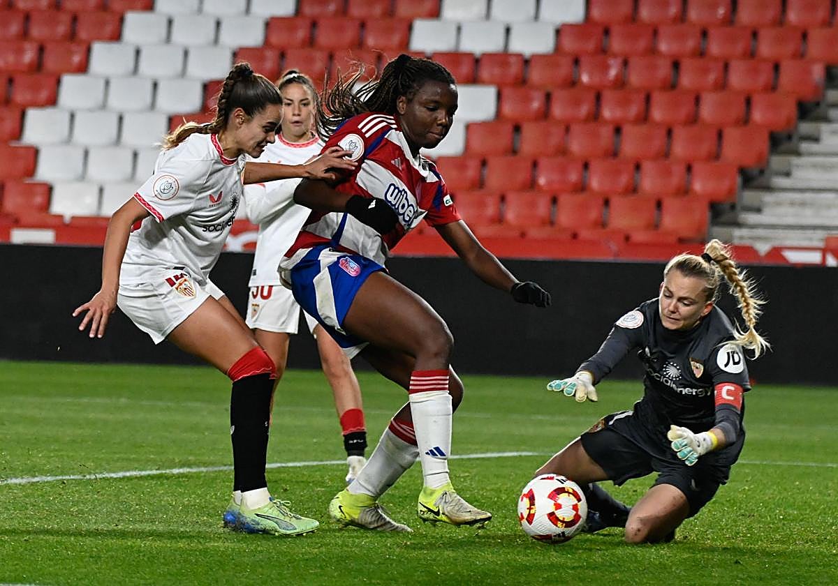 La nazarí Edna trata de regatear a la meta rival en Los Cármenes.