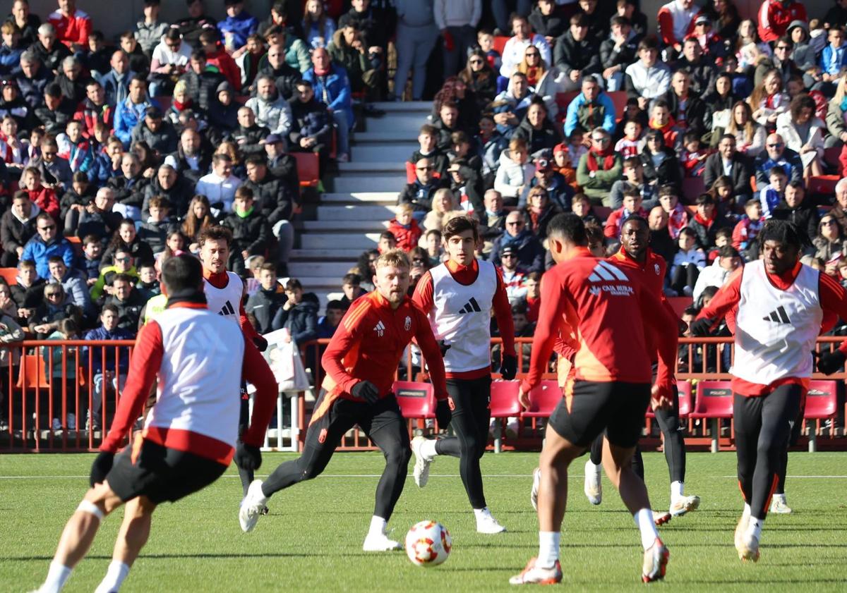 Imagen principal - Los futbolistas del Granada entrenan con el apoyo del público; Loïc Williams firma el cuaderno del pequeño Cayetano. 