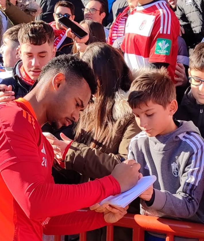 Imagen secundaria 2 - Los futbolistas del Granada entrenan con el apoyo del público; Loïc Williams firma el cuaderno del pequeño Cayetano. 