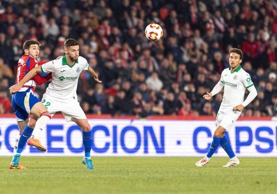 Domingos Duarte despeja un balón, con Luis Milla cerca.