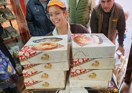 Rosa Cárdenas carga con las cajas de roscones, seguida de Raúl Jaén.