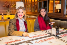 La directora general de La Cueva y su directora de marketing en uno de los restaurantes con los manteles de la campaña.