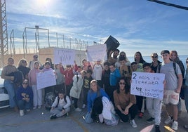 Los niños y padres del colegio de La Rábita con las pancartas en la manifestación, ayer.