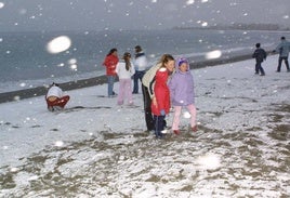 Niños juegan con la nieve en la Playa de Poniente