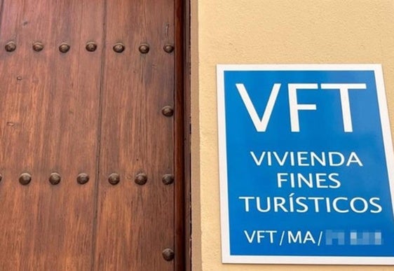 Imagen del portal de una vivienda turística con en el anuncio en la fachada