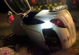 El coche quedó volcado de costado tras salirse de la carretera.