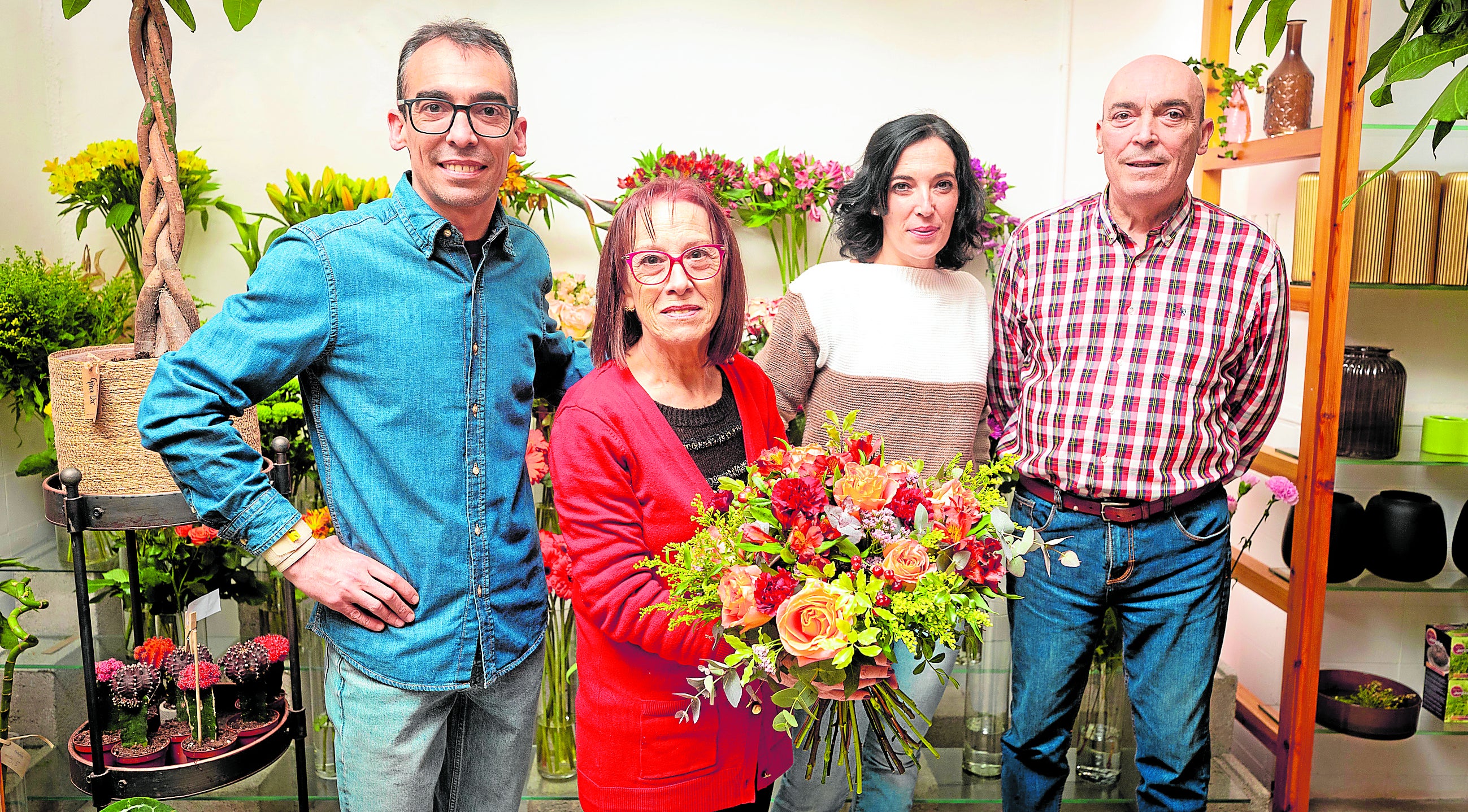 Emilio y María junto a sus hijos, muestran un ramo de flores en su negocio familiar