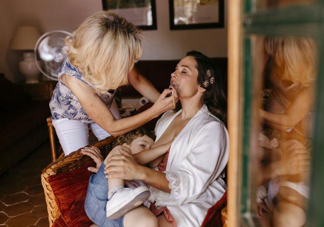 Estrella dando el pecho el día de su boda mientras es maquillada.