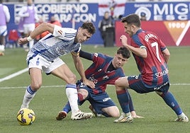 Boyé pelea con dos rivales en el partido en Huesca.