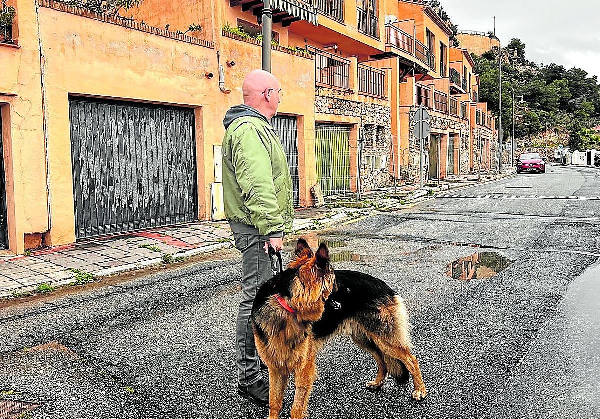 Ricardo pasea a su perro por la urbanización.